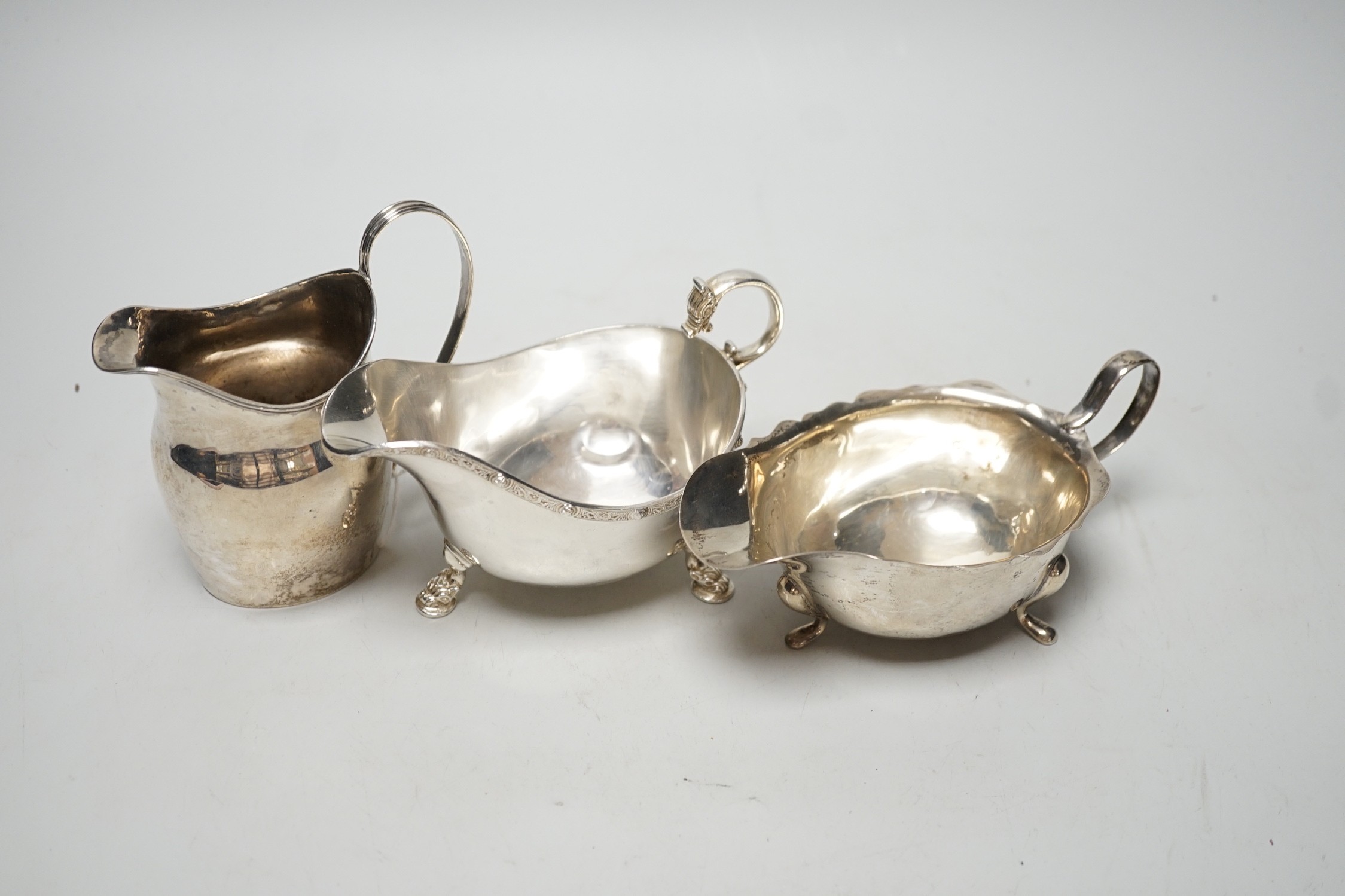 A George III silver cream jug, London, 1801, height 11cm, together with two later silver sauceboats, 10.9oz.